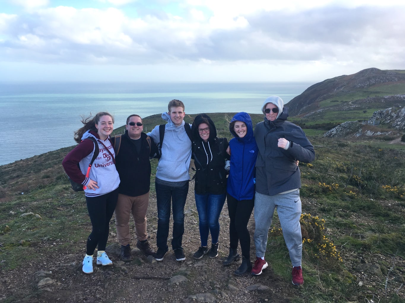 A group of students on a hill overlooking the ocean in Maynooth, Ireland.