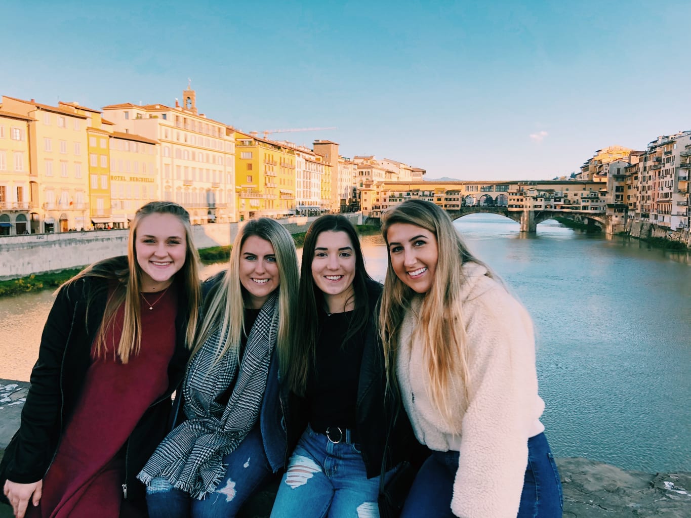 A group of students sitting on a bridge in Florence, Italy.