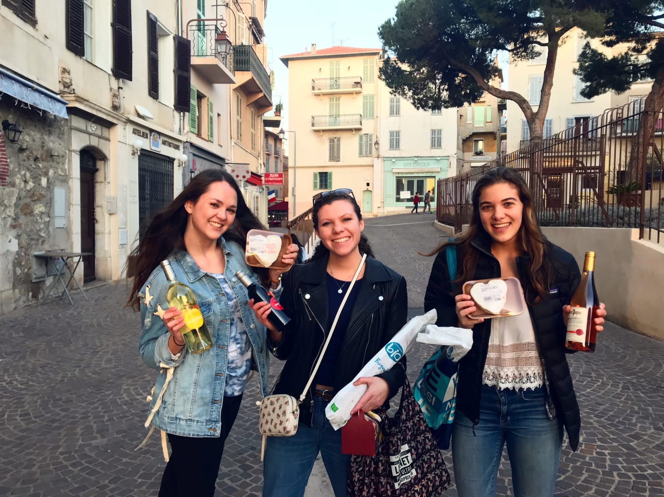 Three girls smiling holding cups.