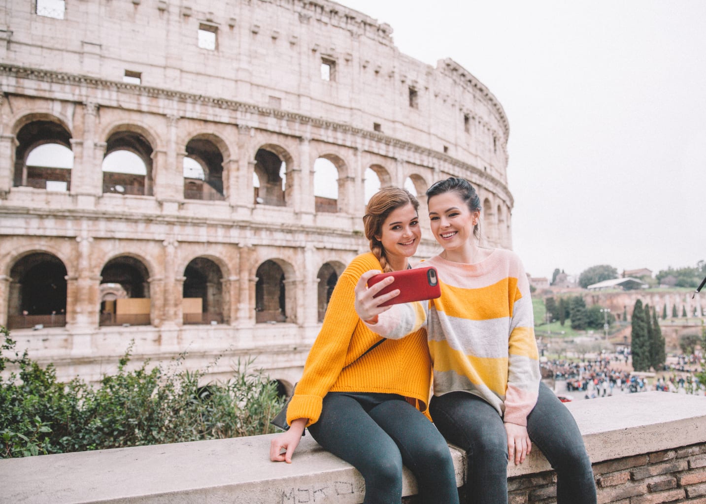 Two students taking a selfie in front of the Colosseum in Italy.