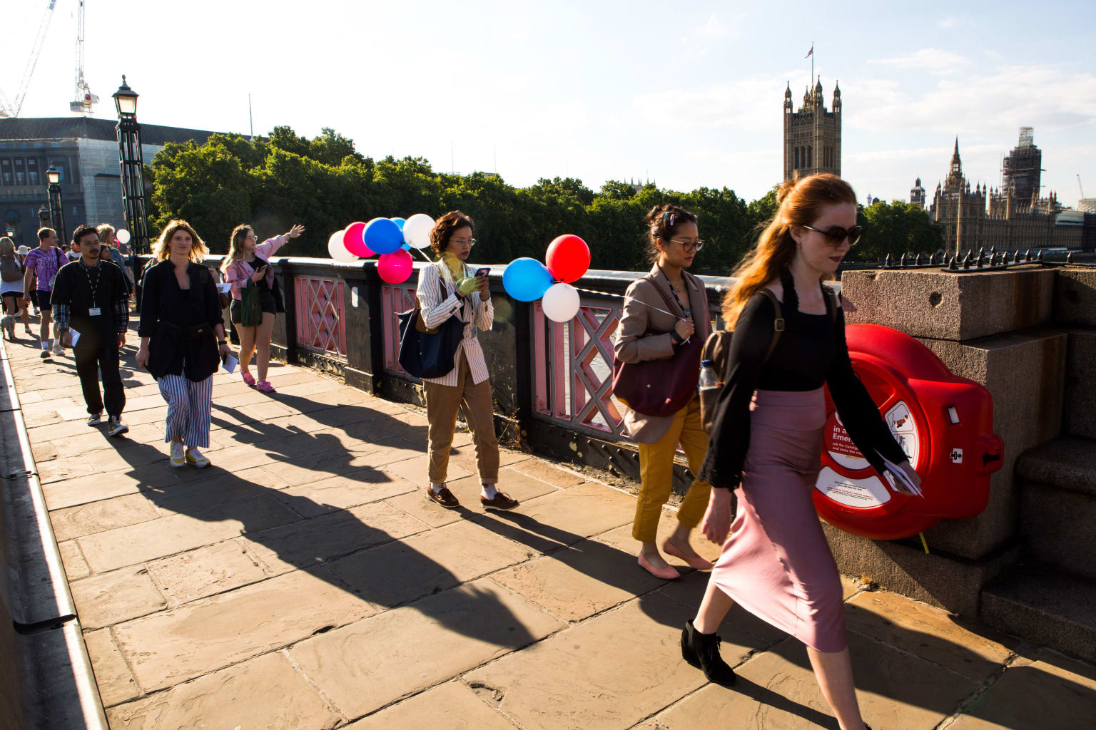 Group of women walking across a bridge in London.