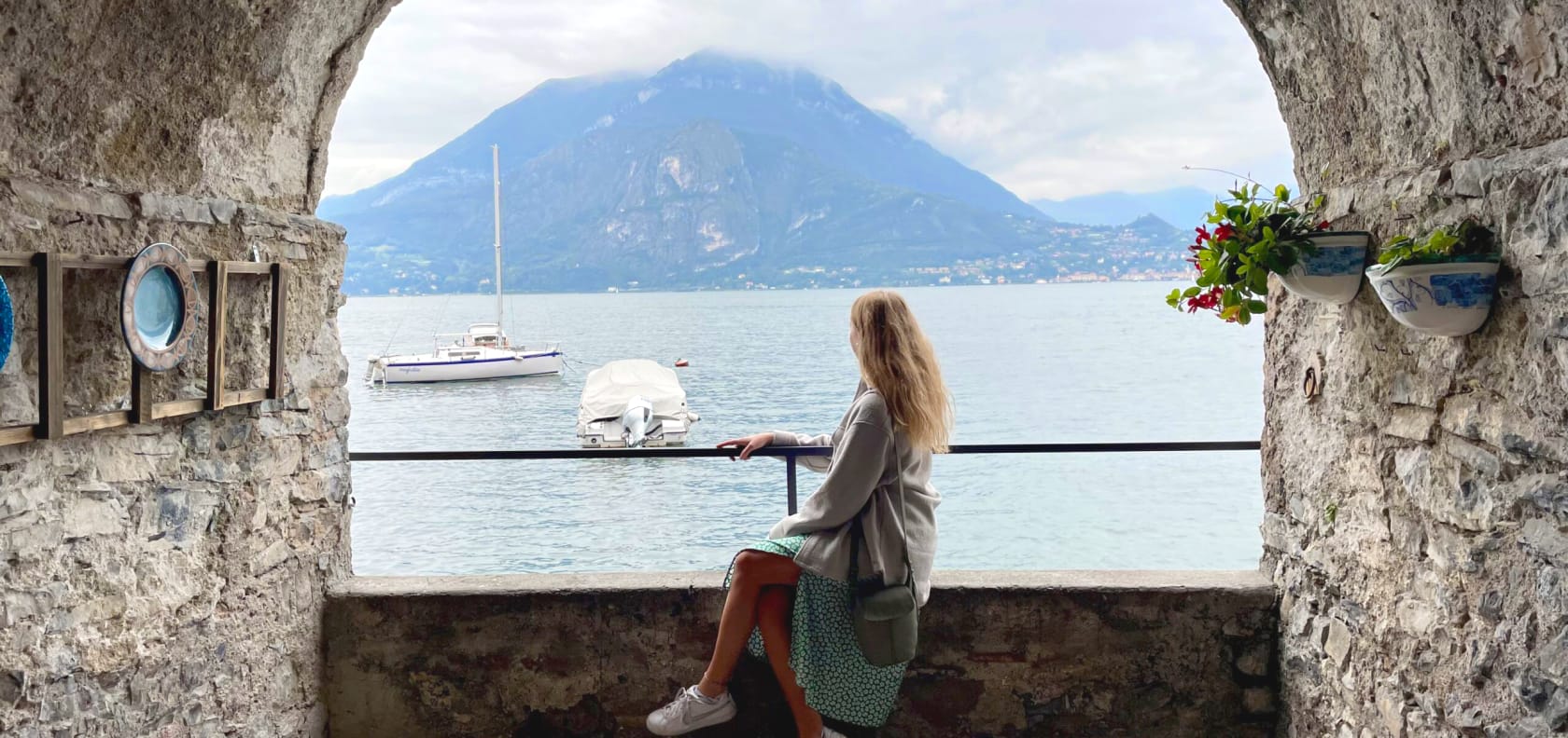 Girl sitting on edge under arch.