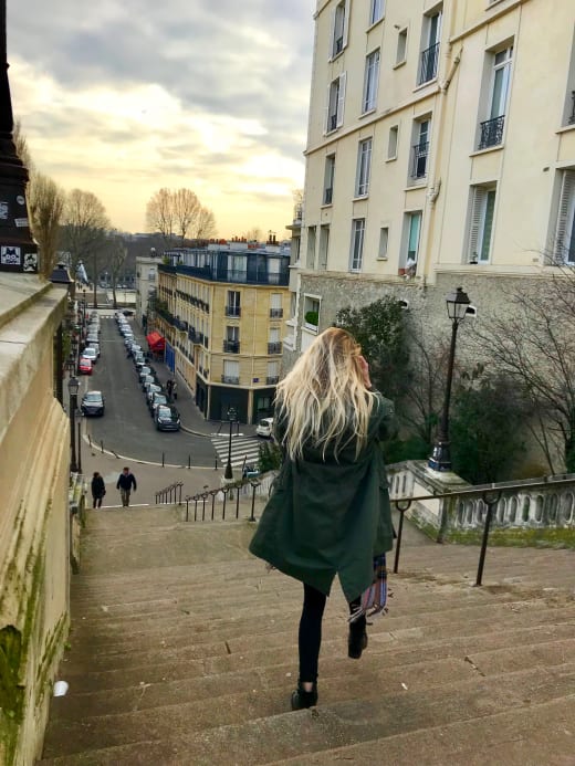 A student walking down a set of stairs in Paris.