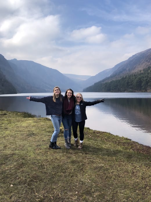 Three students in front of a lake in Ireland.