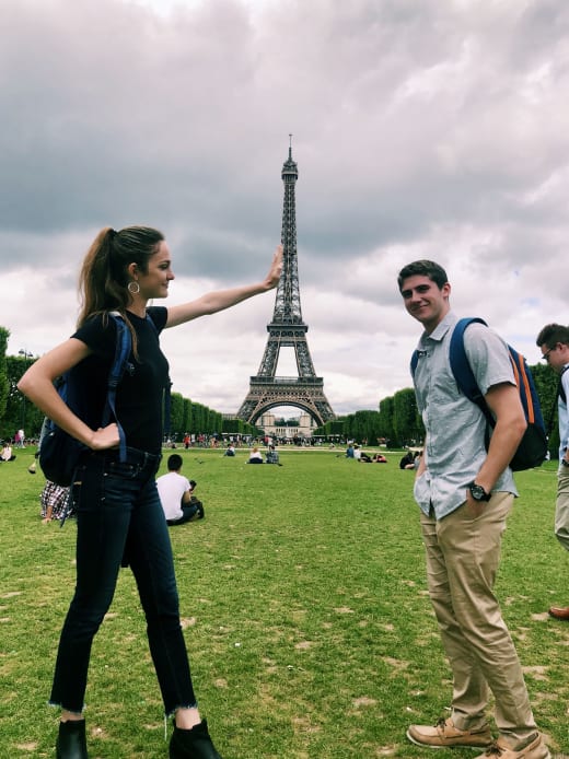 Two students posing with the Eiffel Tower.
