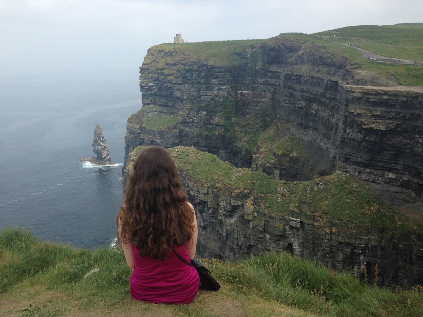 Woman sitting on a cliff in Limerick, Ireland.