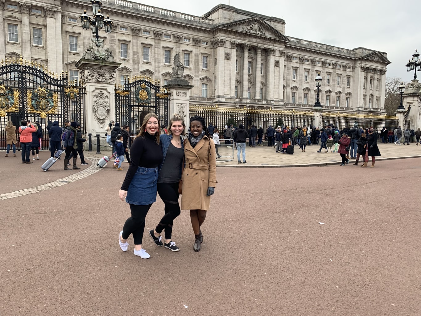 Three students in front of Buckingham Palace.