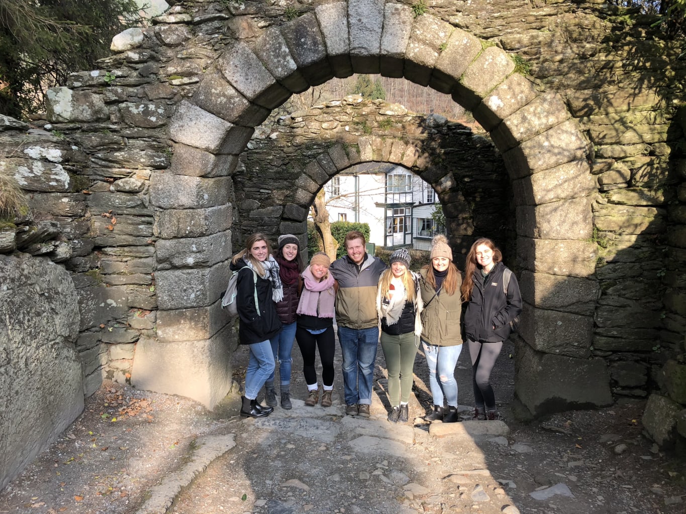 Group of people smiling under arch.