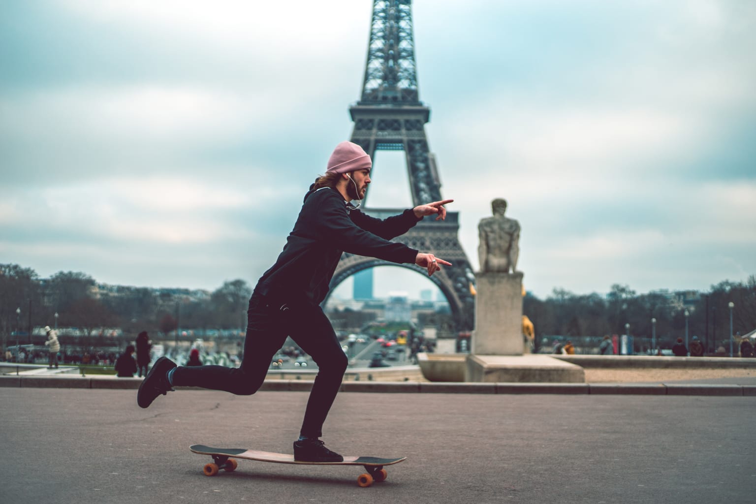 A student skating boarding near the Eiffel Tower.