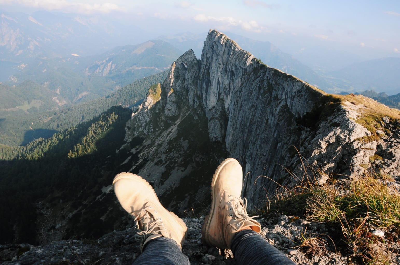 A student's feet resting on the ground in front of a mountain view in Austria.