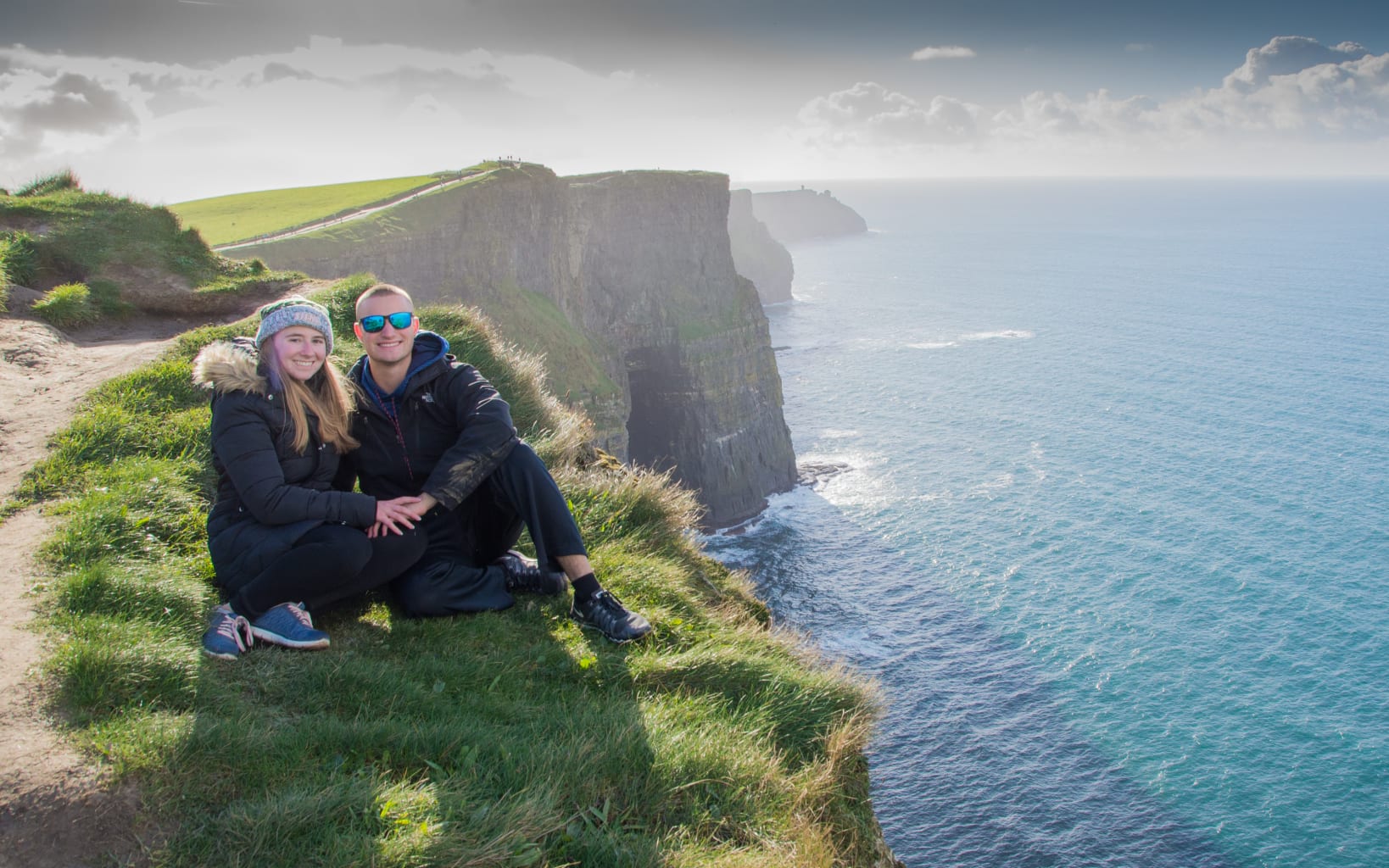 Two students sitting on the cliffs of Moher in Ireland.