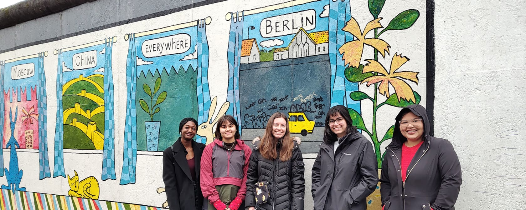 AIFS students in Berlin, Germany, standing next to a mural.