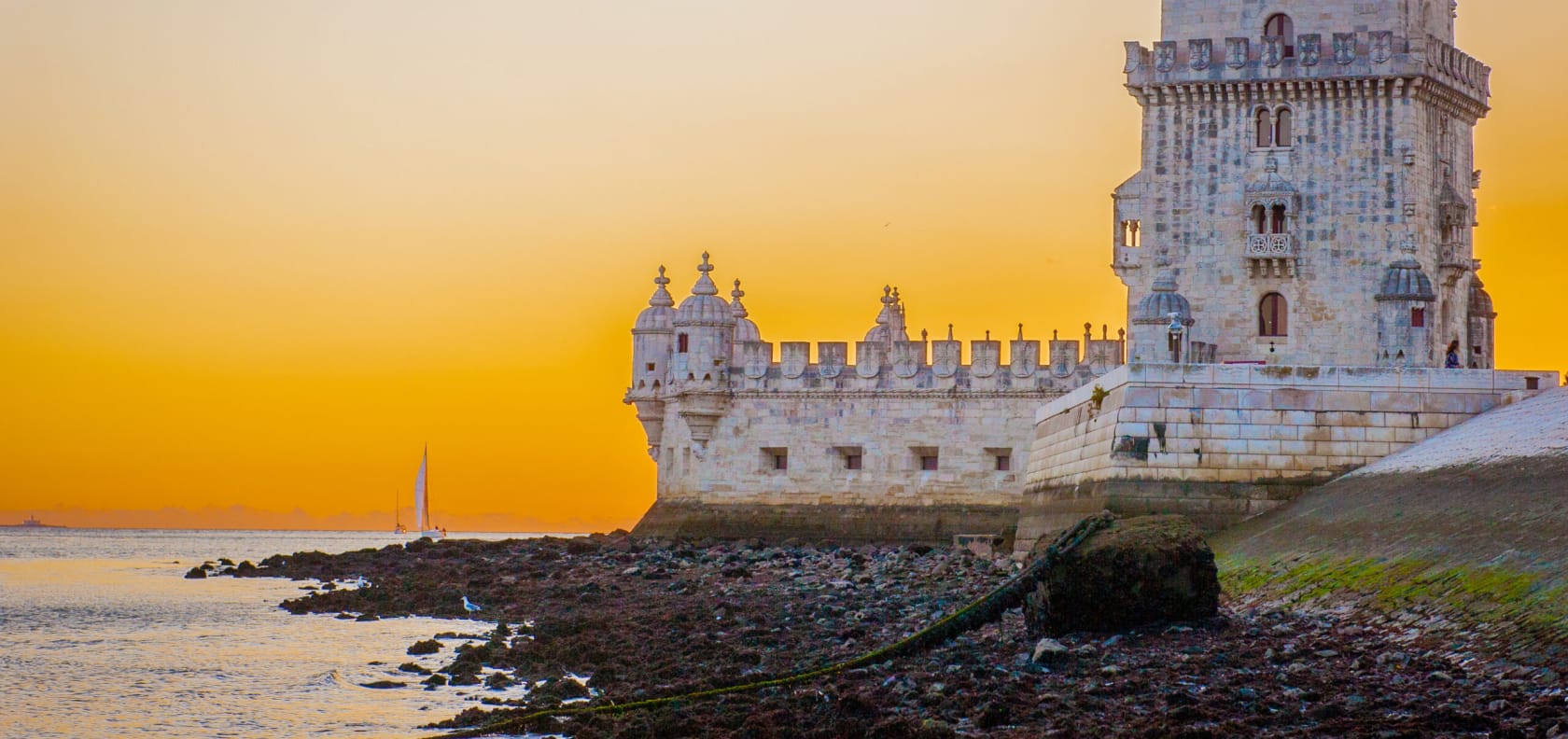 Belém Tower with a sunset in the background.
