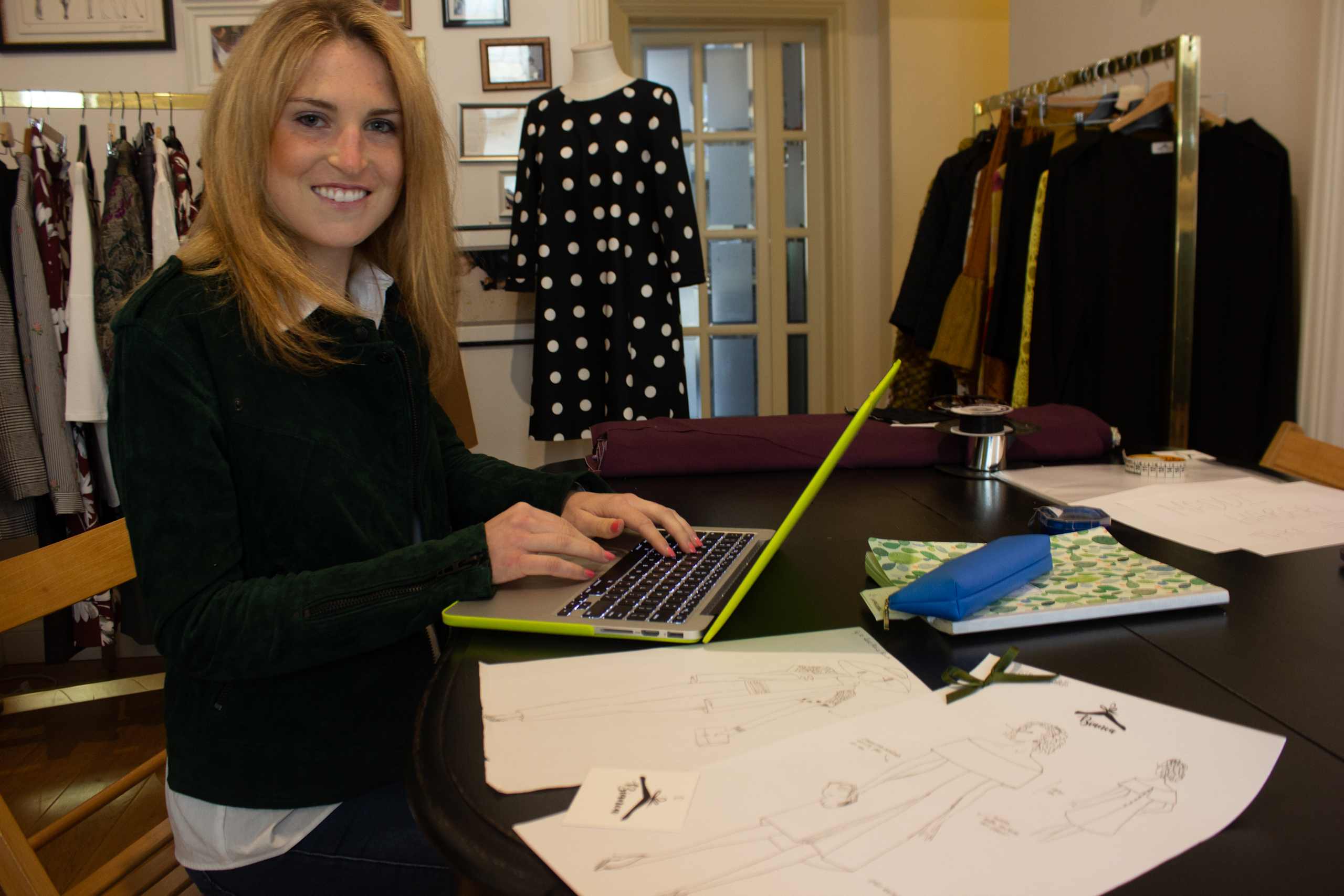 An intern working with a laptop and papers.