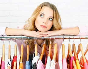 Woman in fashion industry standing by rack of clothing.