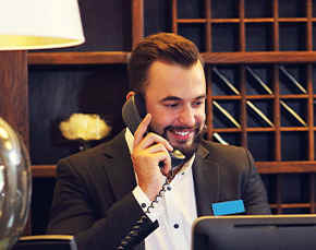 Hotel concierge speaks on telephone