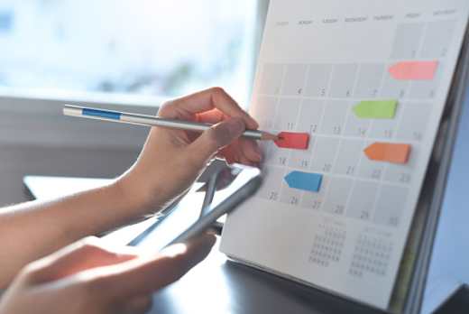 Person marking dates on a calendar.