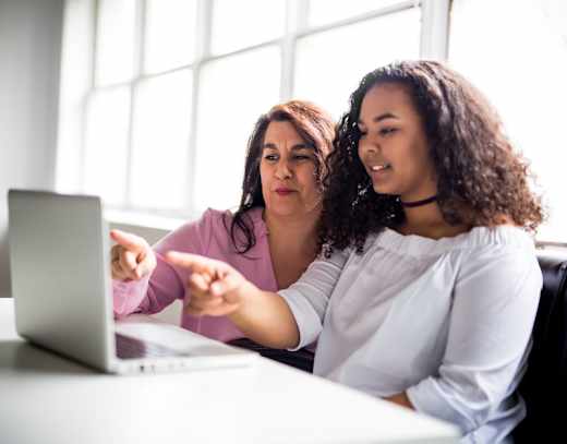 A student and parent looking at a laptop computer.