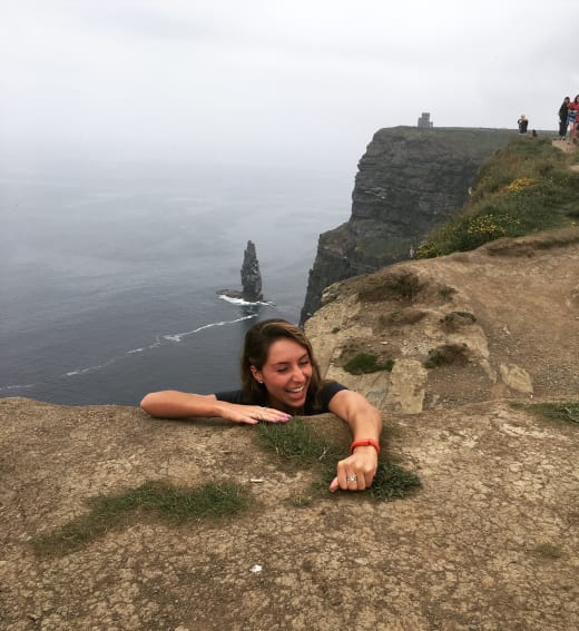 Girl climbing cliff.