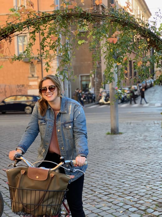 A student on a bicycle in Rome.