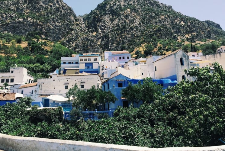 White buildings nestled alongside trees on a mountain in Spain.