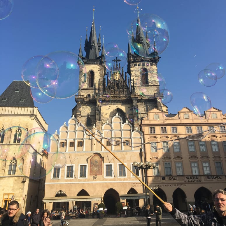 Bubbles floating in front of a building in Prague.