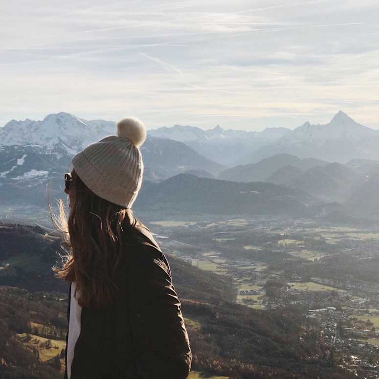 Girl looking behind her shoulder at mountains.